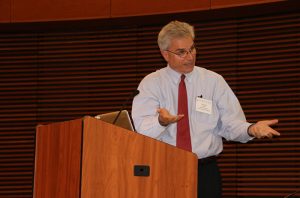 Man talking at a podium using hands