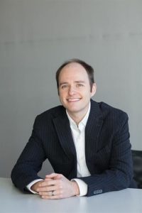 Daniel Agnew sitting at a desk smiling