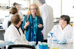 Jo Handelsman speaking with UW instructors in a lab