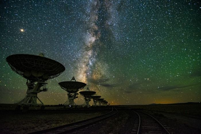 Large satellites silhouetted against a starry sky