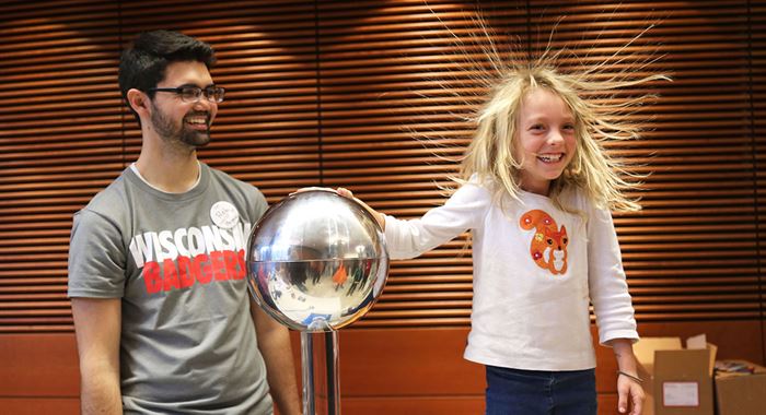 Girl touching a Van der graaf generator hair stands straight up