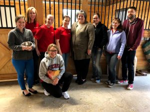 Group of WARF employees posing together in a barn