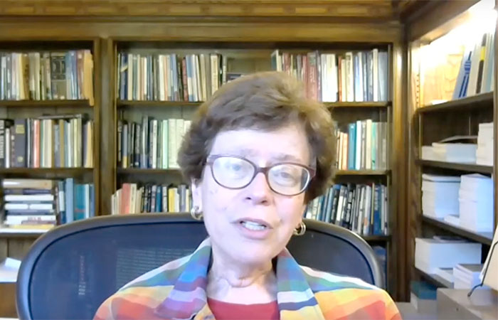 Rebecca Blank sitting surrounded by books on shelves