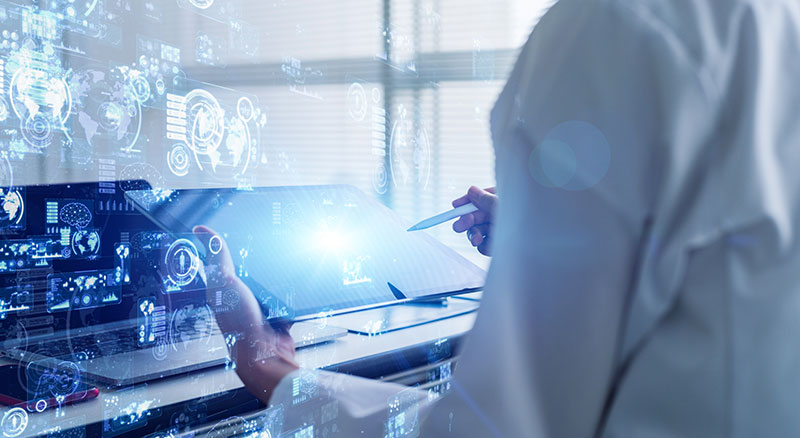 Person in lab coat using futuristic technology and a tablet