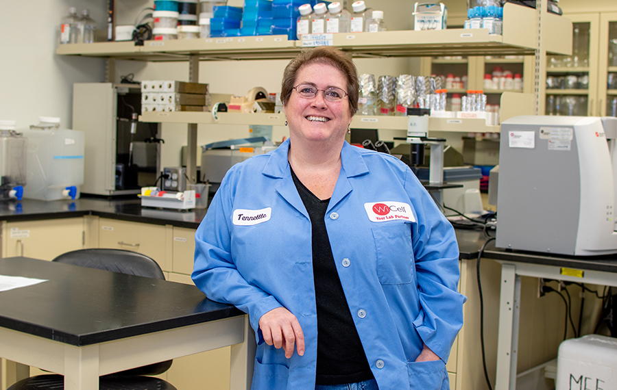 A scientist at the WiCell labs smiles at the camera.