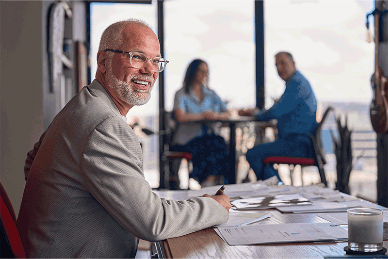 Erik Iverson, WARF's CEO, seated at a table with Deborah Solmor, WARF's general counsel, and Greg Keenan, partner with WARF Ventures, in the background.